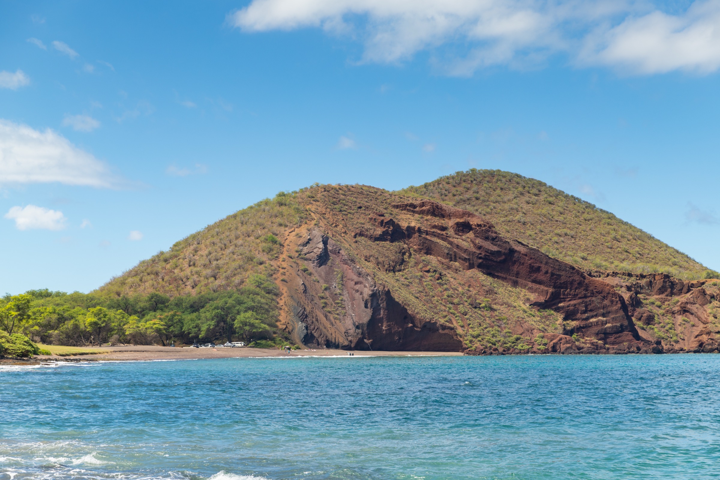 Dark volcanic sand and shoreline at Oneʻuli Beach